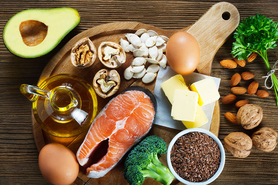 table full of foods rich in Omega 3s such as eggs, salmon, nuts, oils and seeds
